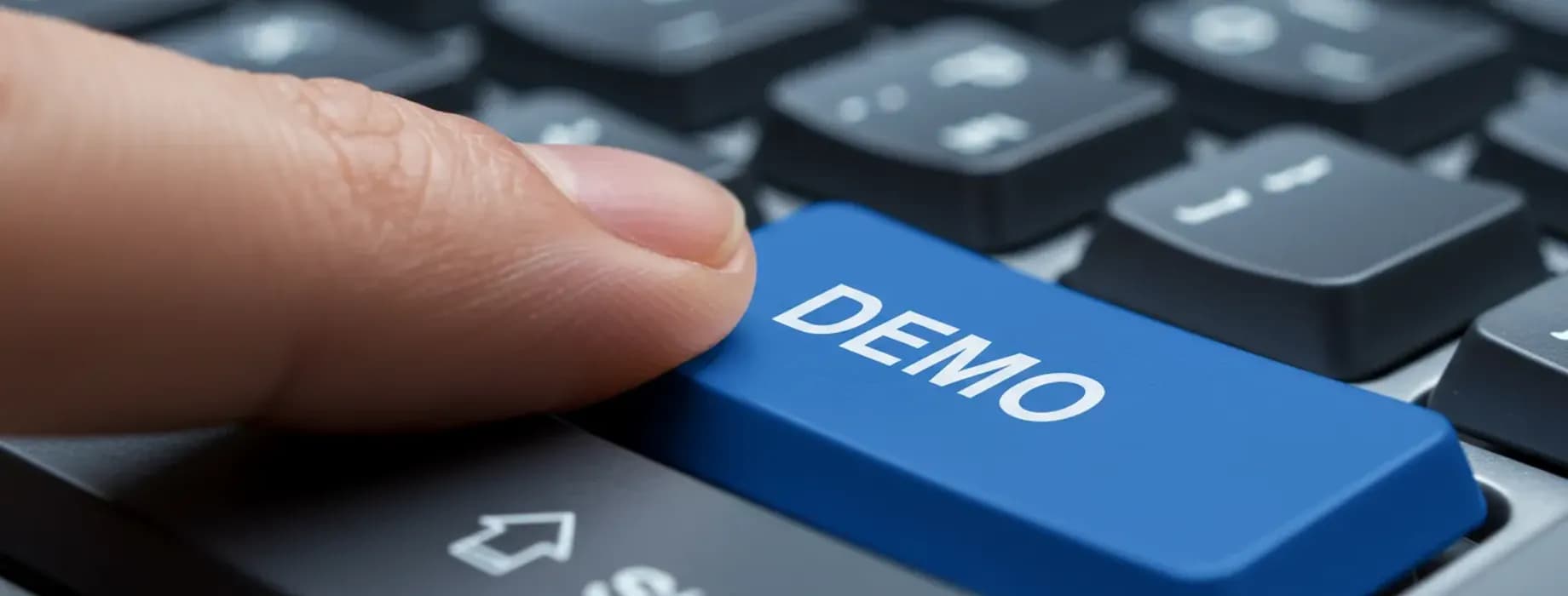 Finger pressing a blue DEMO key on a keyboard — Pocket Option demo account