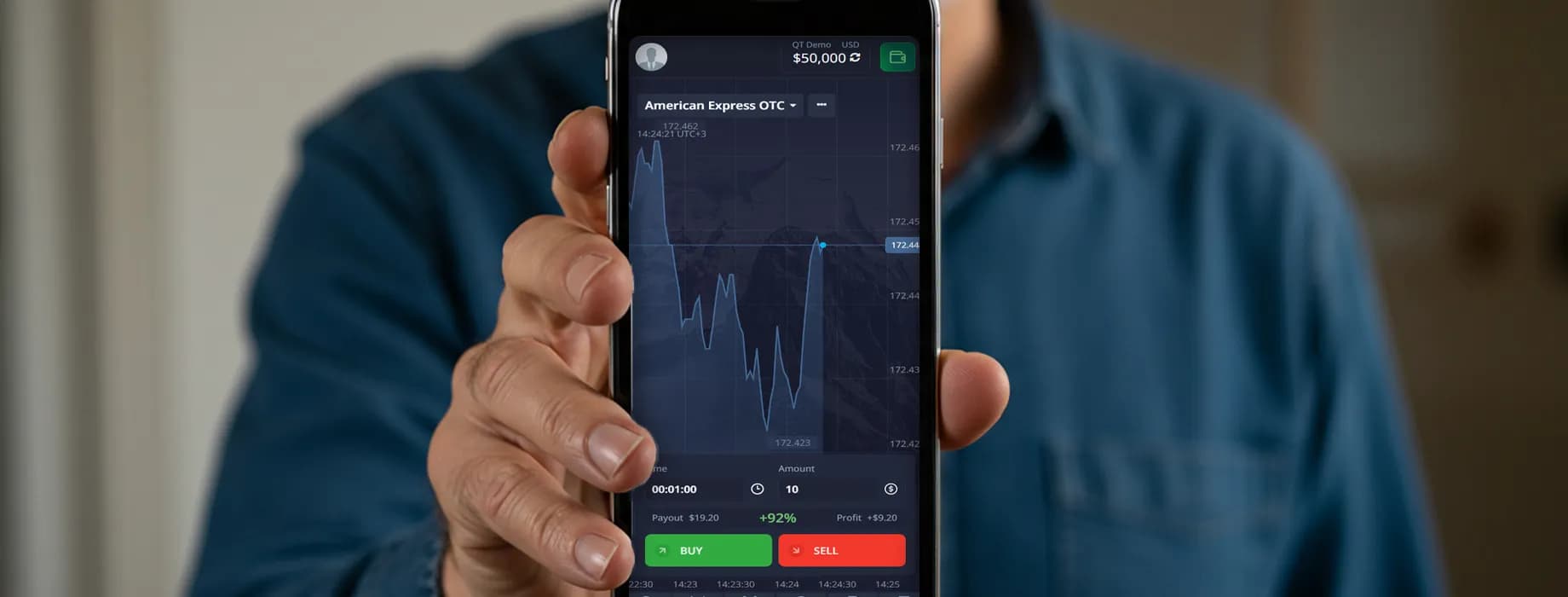 Hand holding a smartphone with the Pocket Option trading app open
